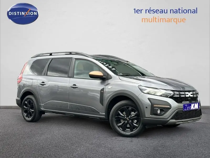 Dacia Jogger gris schiste métallisé vu de profil droit avec jantes noires et barres de toit visibles