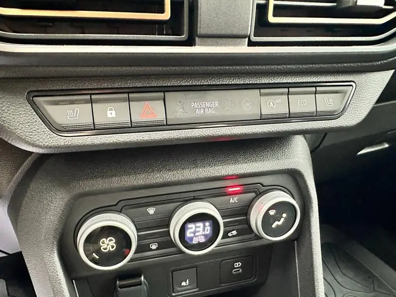 Gros plan sur la console centrale du DACIA JOGGER 2024 montrant les commandes de climatisation et les boutons de sécurité.