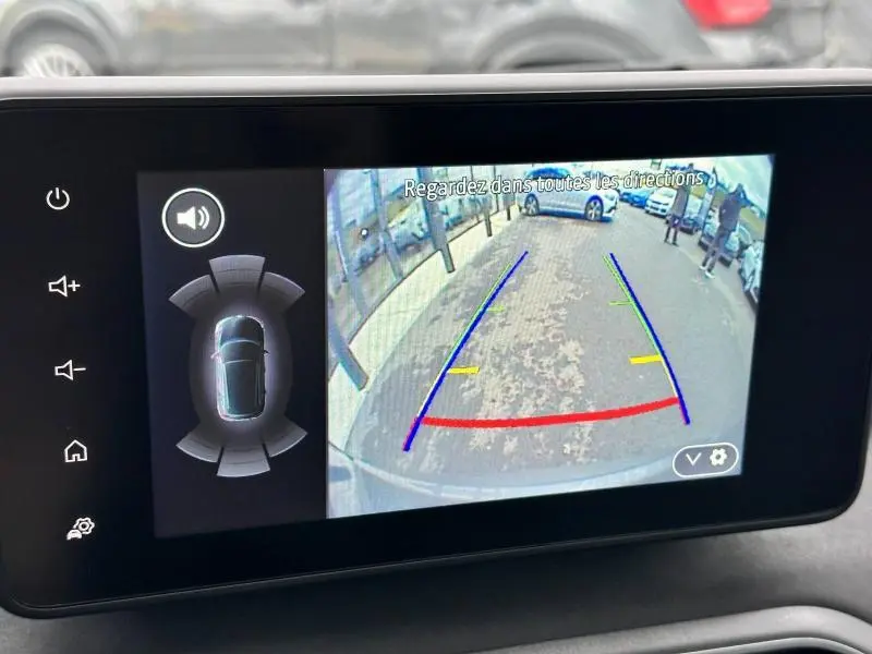 Écran tactile affichant la caméra de recul du Dacia Jogger 2024 avec lignes de guidage colorées et vue arrière du véhicule.