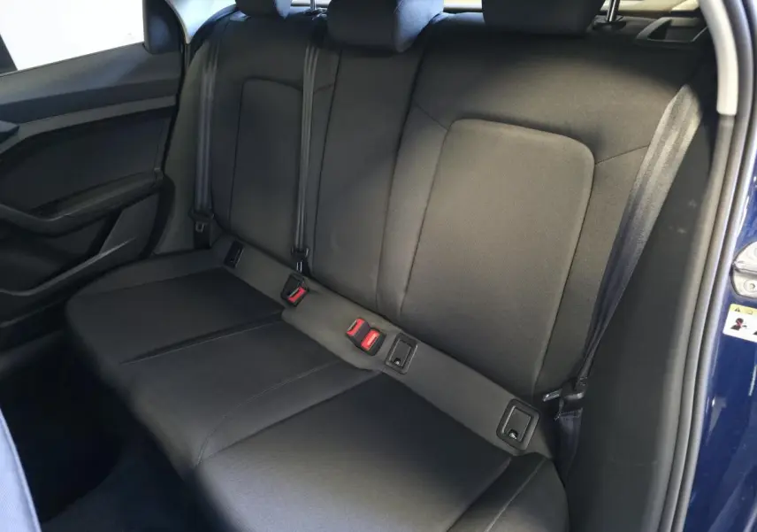 Vue intérieure de la banquette arrière en tissu noir de l'Audi A1 Sportback 2024, porte ouverte côté droit.
