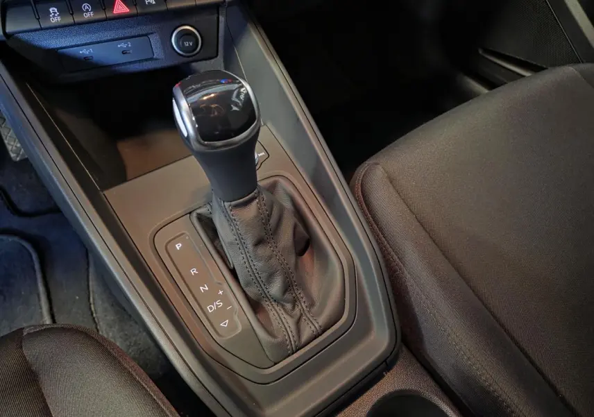 Gros plan sur la console centrale et levier de vitesses automatique de l'Audi A1 Sportback 2024 en tissu noir.
