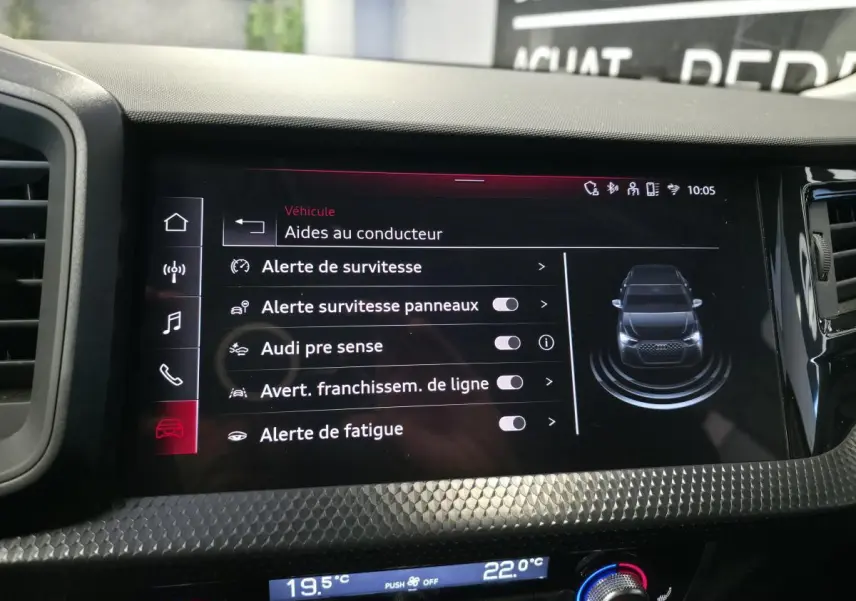 Écran tactile intérieur affichant les aides à la conduite de l'Audi A1 Sportback 2024 avec tableau de bord noir texturé.