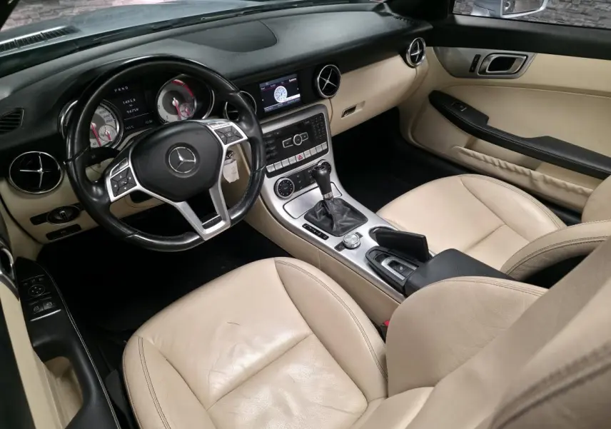 Intérieur beige cuir d'une Mercedes SLK 250 CDI 2012, vue côté conducteur avec tableau de bord et console centrale.