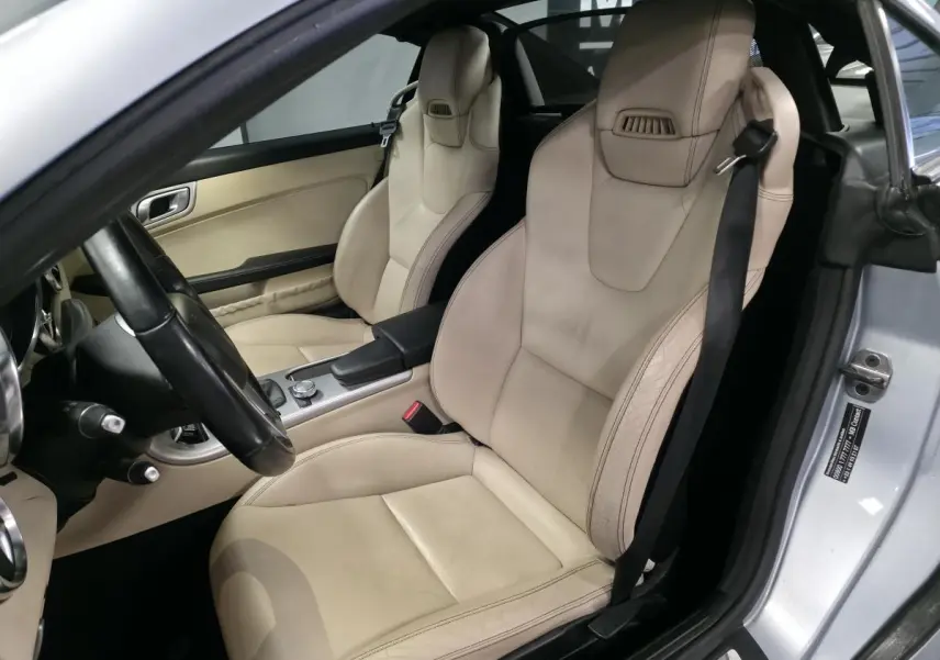 Intérieur de la Mercedes SLK 250 CDI gris, vue côté conducteur sur les sièges sport cuir beige et console centrale.