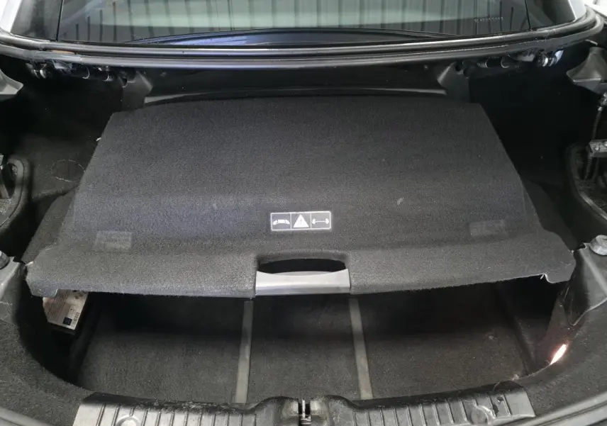 Coffre ouvert d'une Mercedes SLK 250 CDI gris, montrant la séparation intérieure et le revêtement noir.