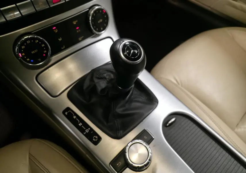 Vue rapprochée de la console centrale d'une Mercedes SLK 250 CDI gris, avec levier de vitesses cuir et sellerie beige.