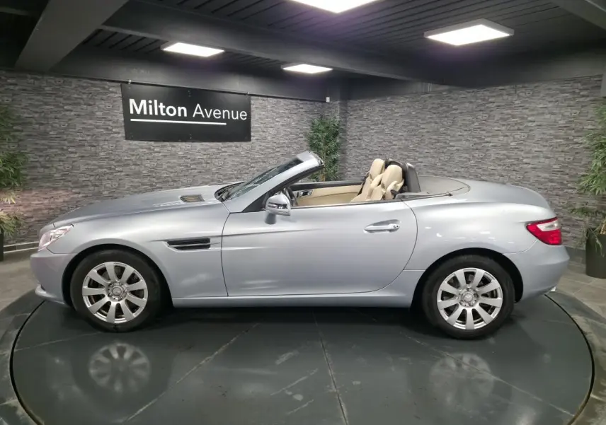 Mercedes SLK 250 CDI gris métallisé vue côté gauche, capote ouverte et sellerie cuir beige visible.