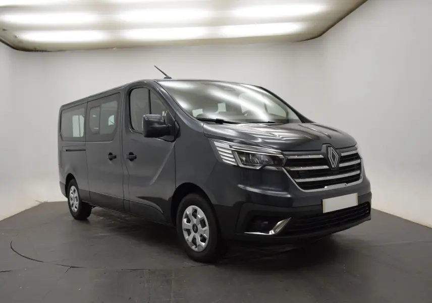 Renault Trafic Combi gris comète en 3/4 avant droit, fourgon 9 places avec calandre chromée et phares LED.