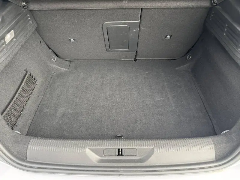 Vue plongeante sur le coffre spacieux et propre du Peugeot 308 2024 en Gris Artense, avec revêtement intérieur sombre.