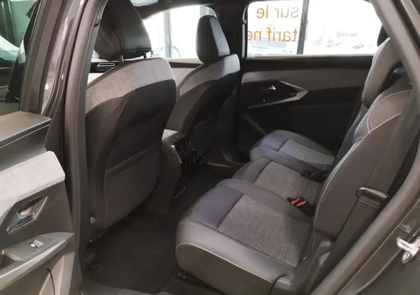 Vue côté droit de l'habitacle arrière du Peugeot 5008 gris titanium avec sellerie tissu et cuir gris foncé.