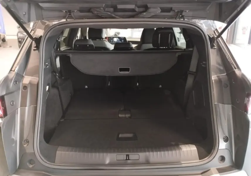 Coffre ouvert du Peugeot 5008 gris titanium, vue arrière montrant l'espace de chargement et la tablette cache-bagages.