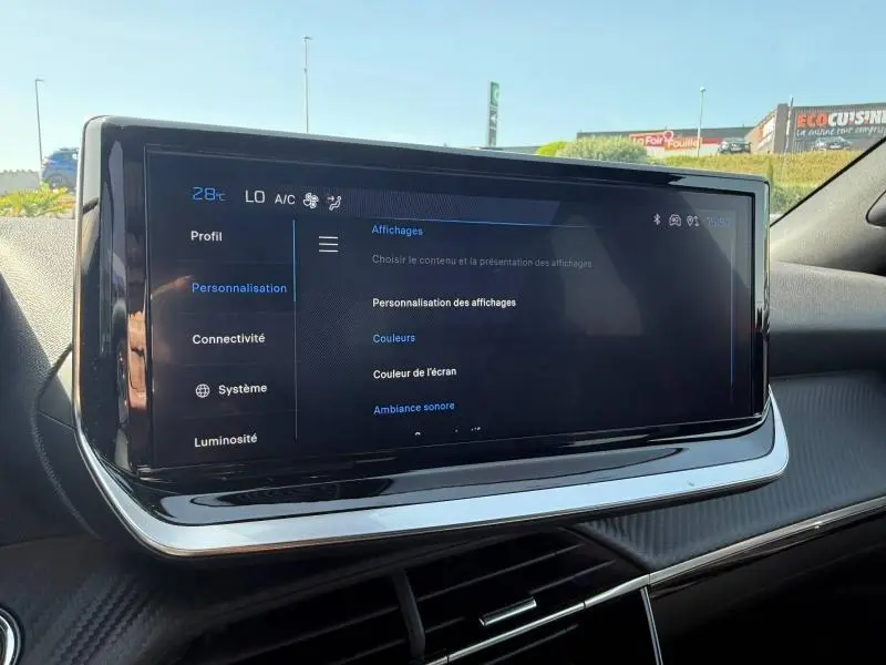 Écran tactile central du tableau de bord du Peugeot 2008 1.2 Hybrid 145ch Allure en intérieur, affichage des réglages.