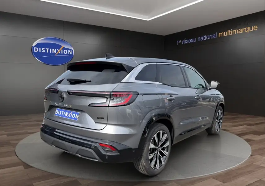 Renault Austral gris foncé en 3/4 arrière droit, avec feux LED et jantes alliage visibles en showroom.