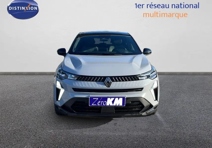 Vue frontale du Renault Captur E-Tech hybride 2025 gris rafale métal avec toit noir et éclairage LED allumé.