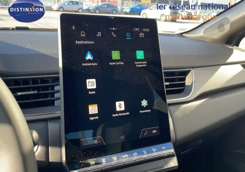 Écran tactile central allumé dans l'habitacle du Renault Captur E-Tech hybride 2025, vue de face côté conducteur.