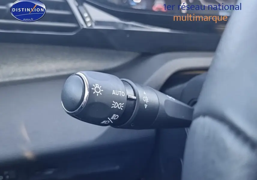 Gros plan sur la commande des phares à gauche du volant dans l’habitacle d’une Peugeot 408 noir 2025.