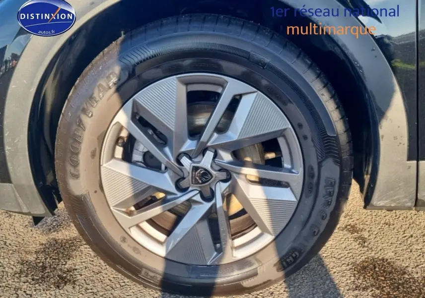 Gros plan sur la jante alu gris clair et le pneu Goodyear du côté avant droit d'une Peugeot 408 noire.