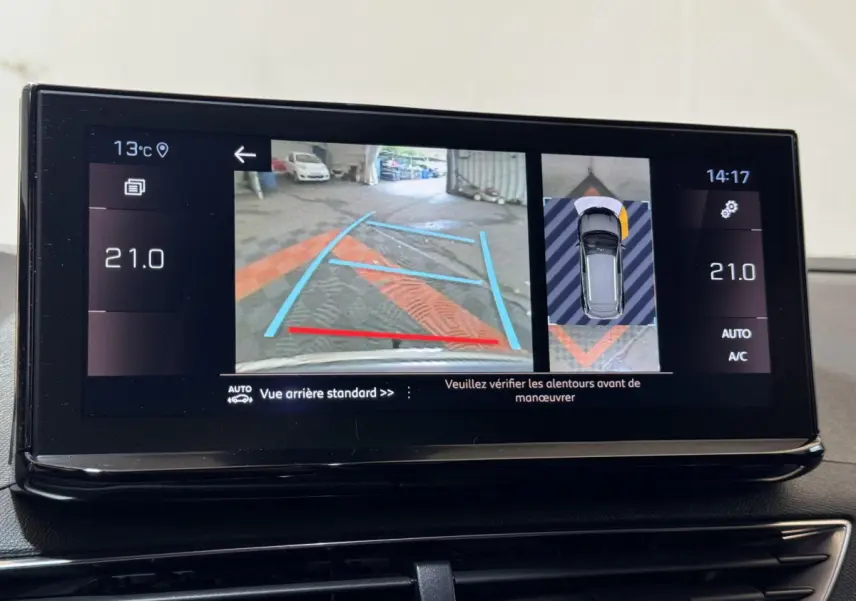 Écran tactile intérieur montrant la caméra de recul et l'aide au stationnement du Peugeot 3008 gris clair, version 2021.