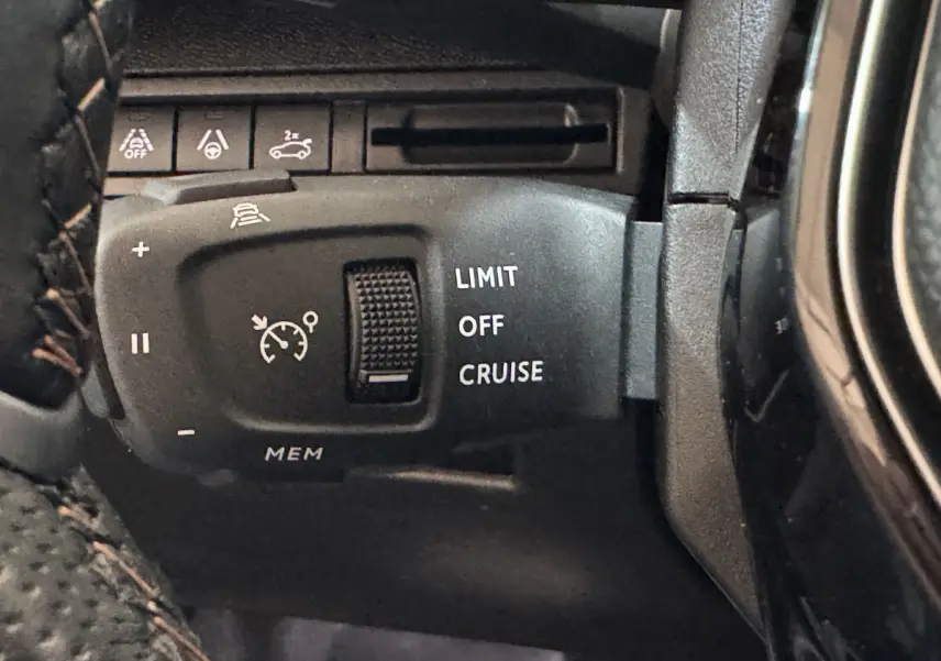 Gros plan sur la commande de régulateur de vitesse du Peugeot 3008 GT 2021, avec boutons noirs et marquages blancs.