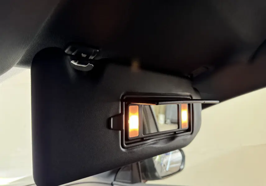 Détail du pare-soleil côté conducteur avec miroir éclairé dans l’habitacle du Peugeot 3008 gris clair.