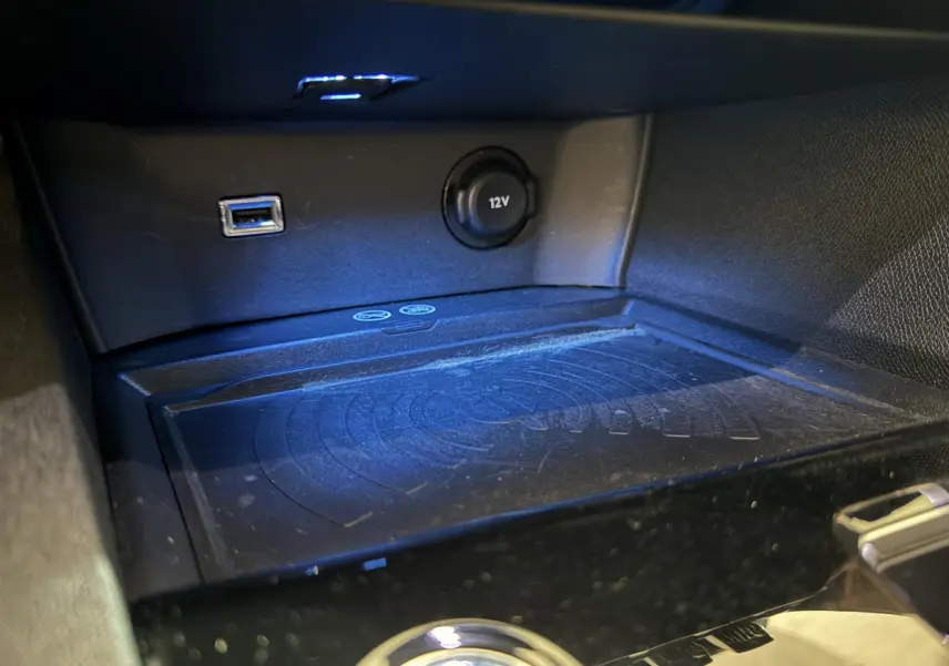 Gros plan sur la console centrale du Peugeot 3008 GT 2021, montrant prise USB, prise 12V et zone de recharge sans fil.