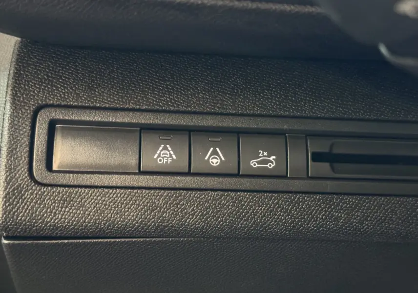 Gros plan sur les boutons de commande d’aide à la conduite dans l’habitacle du Peugeot 3008 gris clair.