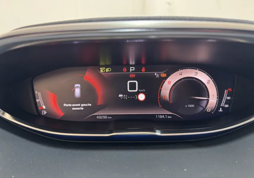 Tableau de bord numérique du Peugeot 3008 gris clair, affichage multifonctions avec alerte porte avant gauche ouverte.