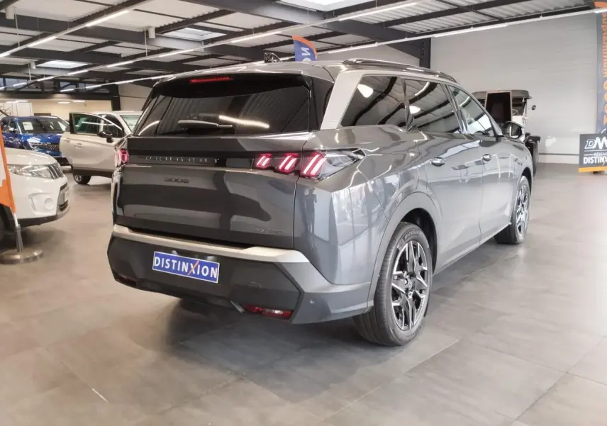 Vue 3/4 arrière droite d'un Peugeot 5008 gris titanium avec feux arrière LED 3 griffes et jantes alliage 19 pouces.