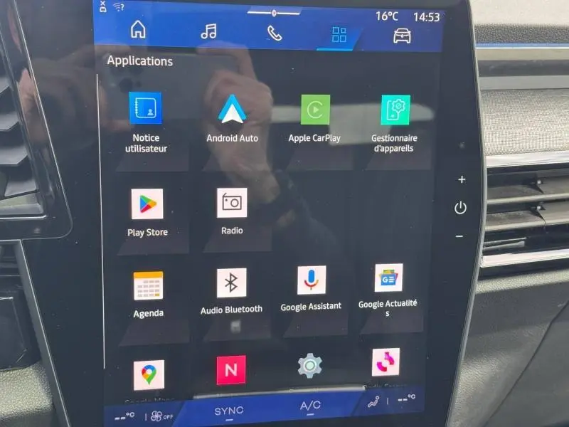 Écran tactile central du Renault Austral 2025 affichant les applications connectées, avec tableau de bord et aérateurs visibles.