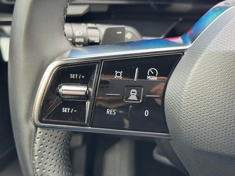 Détail du volant côté gauche du Renault Austral 2025 hybride, avec commandes de régulateur et mode de conduite.