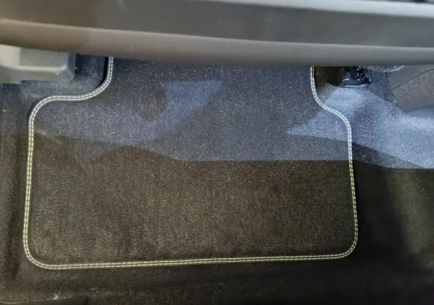 Tapis de sol noir avec surpiqûres blanches, vue rapprochée de l'intérieur côté conducteur du Peugeot 3008 2025.