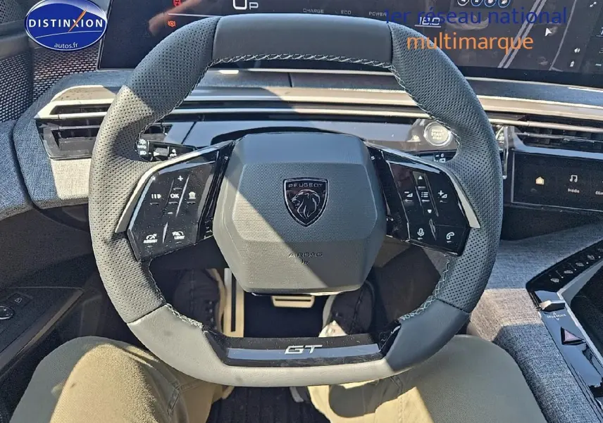 Volant cuir perforé GT de Peugeot 5008 Hybrid 145 gris titane vu de face avec commandes multifonctions.