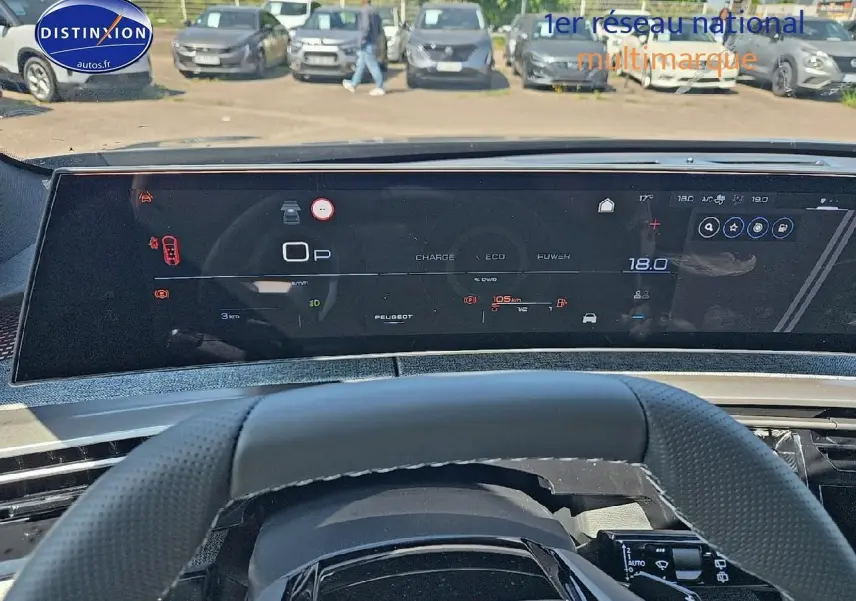 Vue du tableau de bord numérique et volant cuir perforé du Peugeot 5008 Hybrid 145 GT gris titane 2025.