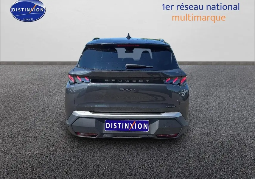 Vue arrière d'un Peugeot 5008 Hybrid 145 GT gris titane avec feux arrière LED et hayon fermé.