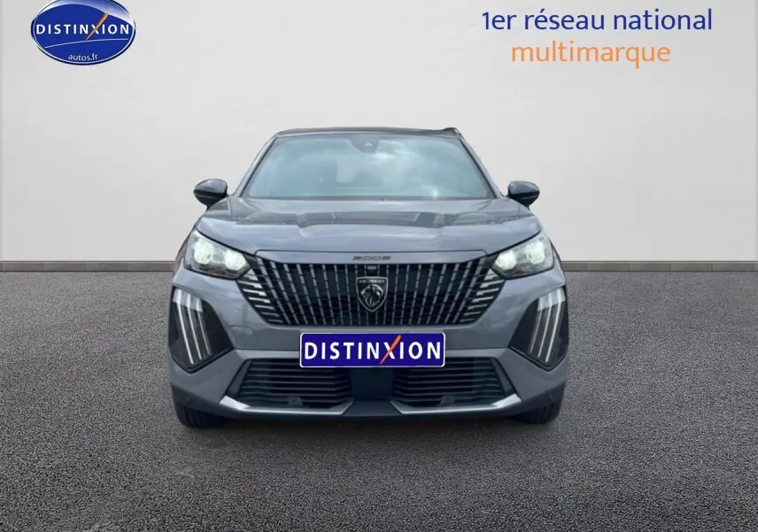 Vue avant du Peugeot 2008 E-136 allure gris sélénite avec calandre noire et feux LED allumés.