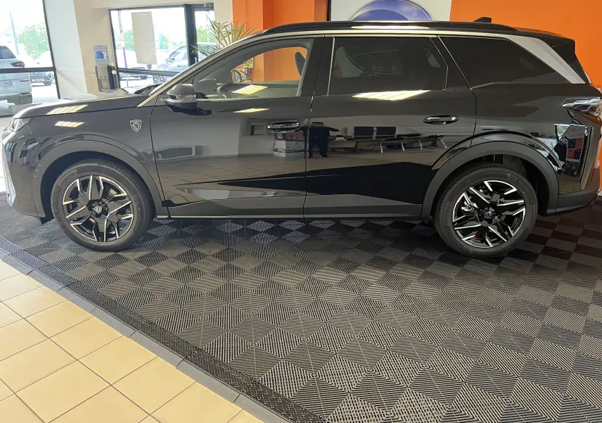 Profil côté gauche du SUV Peugeot 5008 noir 2025 avec jantes alliage 19’’ et toit contrasté Black Diamond.