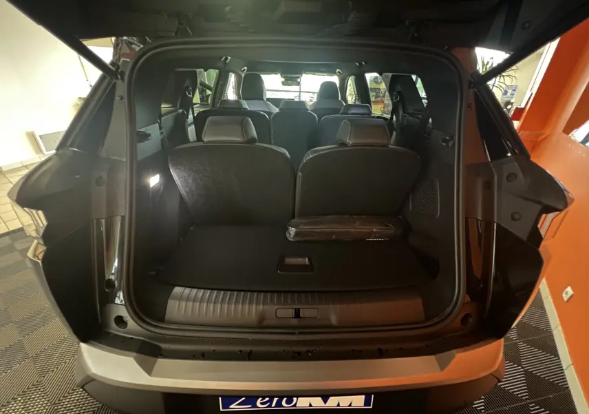 Coffre ouvert vue arrière d'un Peugeot 5008 noir 2025, montrant les sièges arrière et l'espace de chargement.