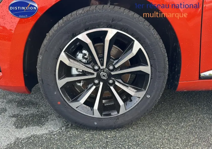 Gros plan sur la jante alu noire et argentée de la Renault Clio V orange Valencia côté avant droit.