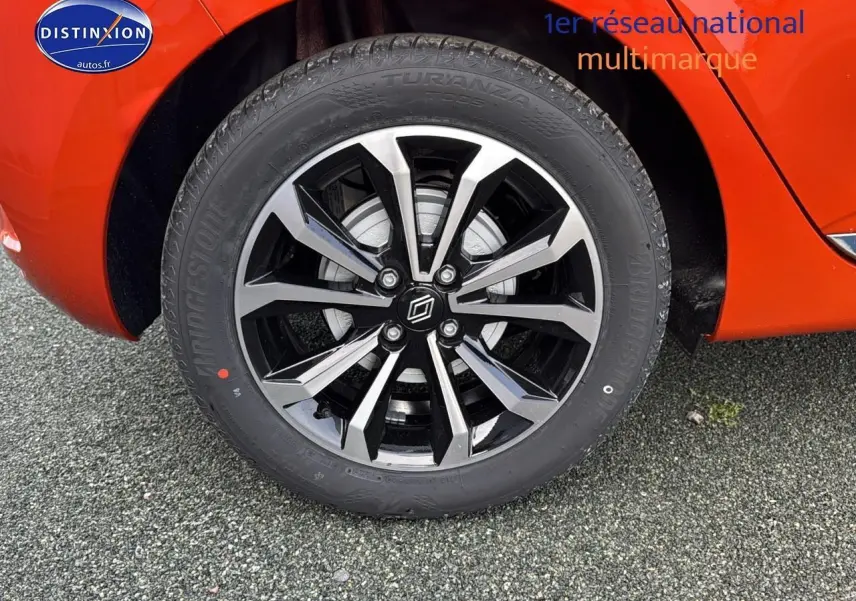 Gros plan sur la jante alu noire et argent de la Renault Clio V orange Valencia, avec pneu Bridgestone Turanza.