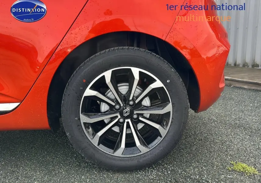 Gros plan sur la roue arrière droite de la Renault Clio V orange Valencia avec jante alliage noire et argentée.