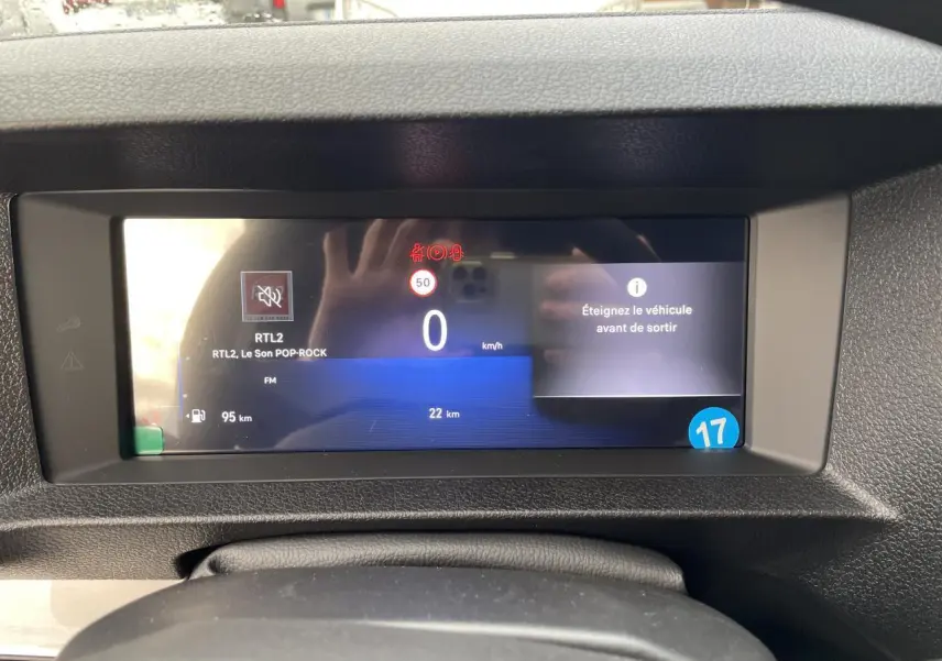 Écran numérique du combiné de bord de l'Opel Vivaro blanc, affichant vitesse, radio et alertes.