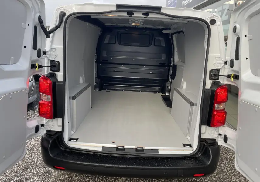Vue arrière du fourgon blanc Opel Vivaro 2024 avec portes ouvertes montrant un plancher et coffrage en bois.