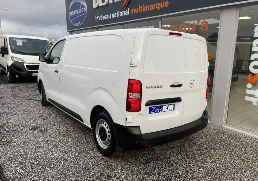 Vue 3/4 arrière droite d'un Opel Vivaro blanc avec portes arrière battantes et jantes tôles grises.