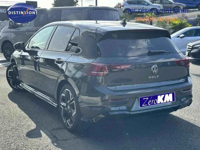Vue 3/4 arrière droite d'une Volkswagen Golf gris foncé 2025 R-Line Edition avec jantes sport et vitres teintées.