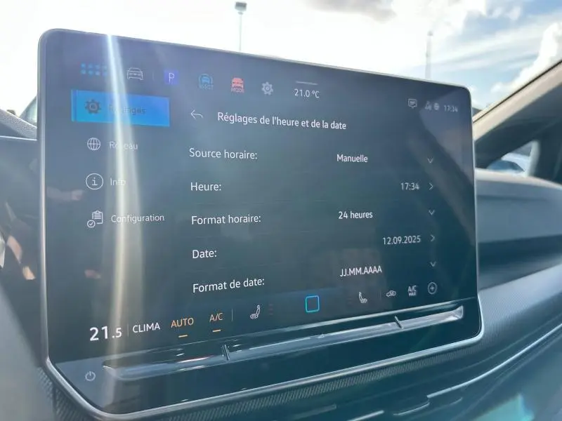 Écran tactile central du tableau de bord de la Volkswagen Golf 1.5 eTSI R-Line Edition 2025, affichant les réglages de date et heure.
