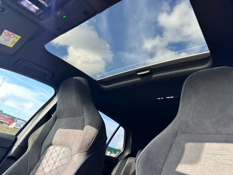Vue intérieure du toit ouvrant panoramique et des sièges sport gris de la Volkswagen Golf 1.5 eTSI R-Line Edition 2025
