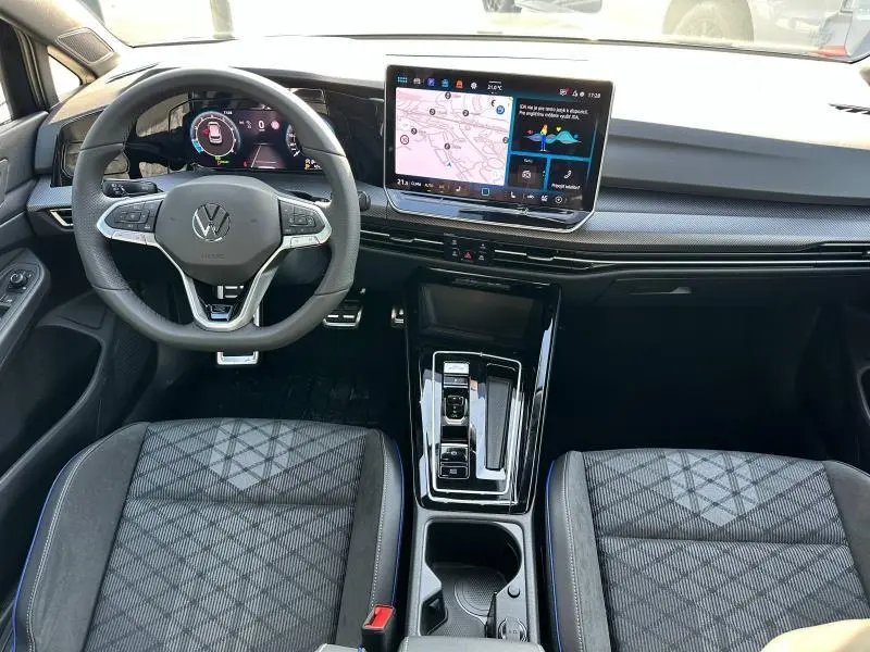 Vue intérieure avant de la Volkswagen Golf 1.5 eTSI R-Line 2025, avec tableau de bord numérique et écran tactile central.