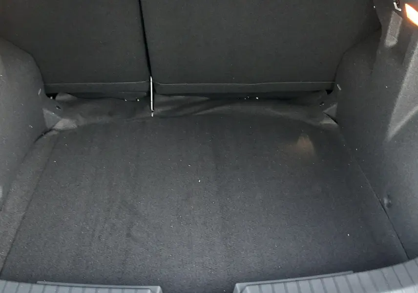 Coffre spacieux du Dacia Duster 2025 en version 1.6 Hybrid 140ch Extreme, vue intérieure arrière avec revêtement noir.