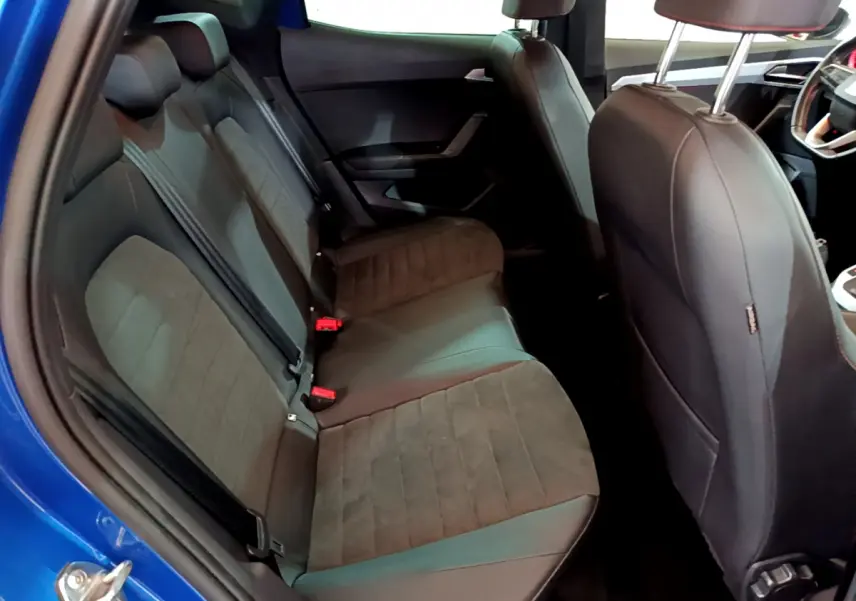 Vue intérieure côté arrière droit du SEAT Arona bleu 2022, montrant la banquette arrière en tissu et cuir noir.