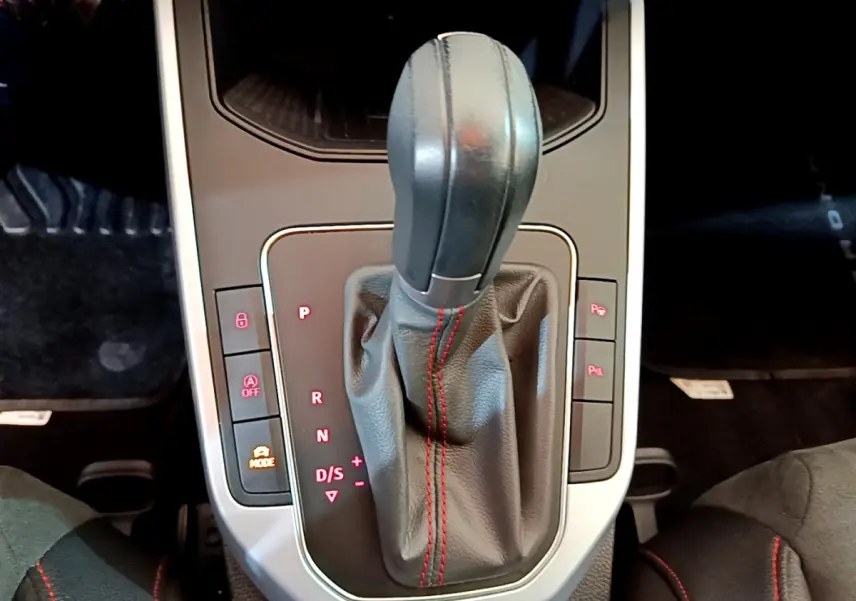 Le levier de vitesses automatique noir avec surpiqûres rouges du SEAT Arona 2022 vu de dessus, console centrale.